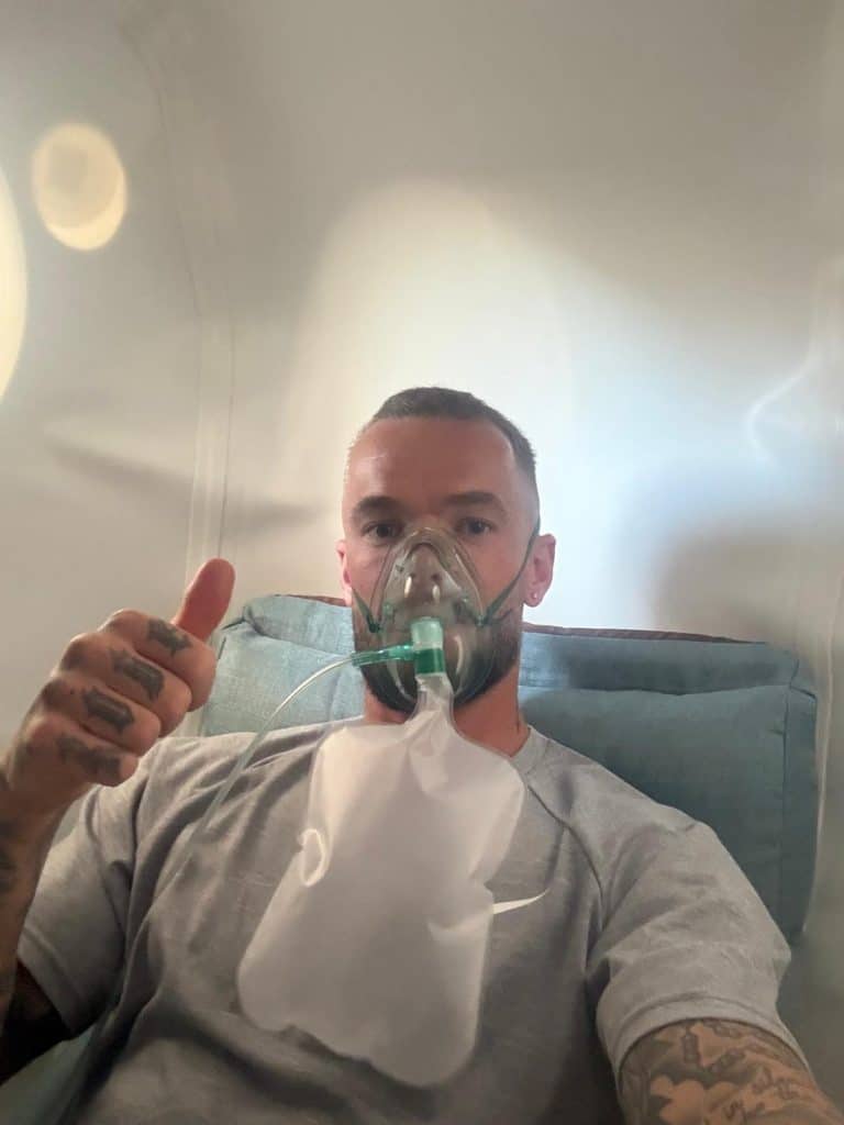 Person inside hyperbaric chamber wearing oxygen mask